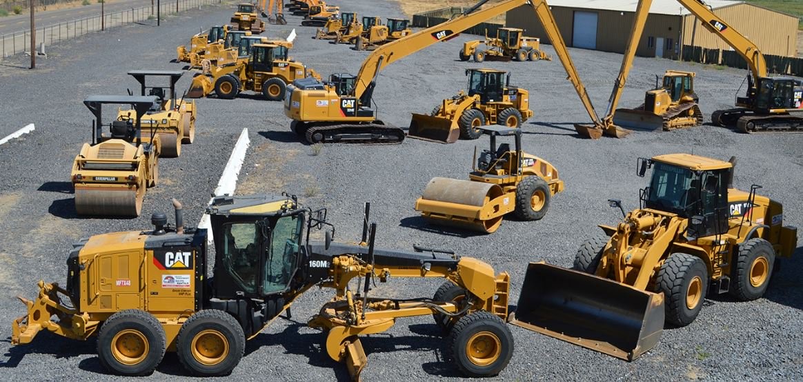 A yard full of Caterpillar construction equipment: graders, excavators, loaders, and compactors
